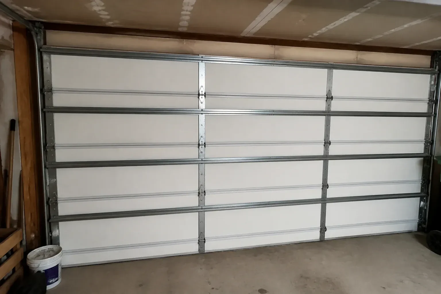 Interior of a closed sectional door with horizontal metal reinforcement struts. — Wind-Rated Garage Door Replacement, Mississauga